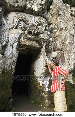 Stock Image - Indonesia, Bali, Goa Gajah (Elephant Cave), Balinesian Man Gazing In Cave.. Fotosearch