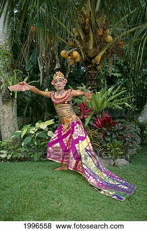 Indonesia, Bali, Kebyar Duduk Dancer Wears Colorful Outfit Tropical Surroundings A63F View Large Photo Image Stock Photo - Indonesia, Bali, Kebyar Duduk Dancer Wears Colorful Outfit Tropical Surroundings A63F. Fotosearch