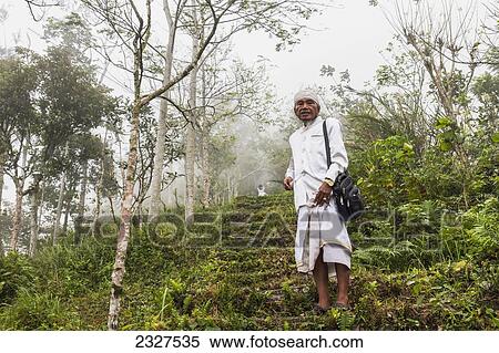 Stock Photography - Indonesia, Bali, on Bali's East side; Abang, Mount Agung, Elderly Hindu man on steps towards Lempuyang Temple which overlooks Bali's highest point. Fotosearch