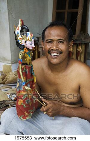 Stock Image - Indonesia, Bali, Pellatan Village, Master Puppet Maker With Creation.. Fotosearch