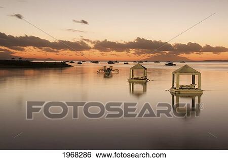 Stock Photograph - Indonesia, Bali, Sanur Beach, Sunrise, Floating Huts That Can Be Used For Romantic Dinner For Two, Relaxing, Or Special Requests.. Fotosearch