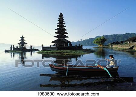 Stock Image - Indonesia, Bali, Ulu Danu Temple At Sunrise, Canoe Paddling By No Model Release. Fotosearch