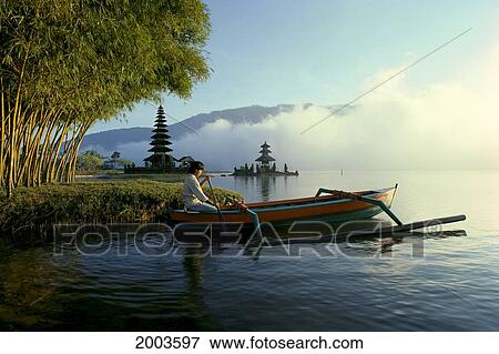 Indonesia, Bali, Ulu Danu Temple, Man With Boat On Water, Fog, Sunrise View Large Photo Image Stock Photo - Indonesia, Bali, Ulu Danu Temple, Man With Boat On Water, Fog, Sunrise. Fotosearch