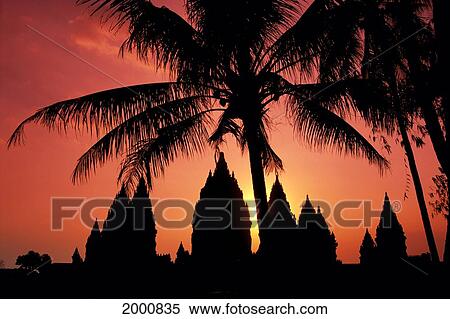 Stock Photography - Indonesia, Java, View Of Palm Trees And Buildings Silhouetted At Sunset. Fotosearch