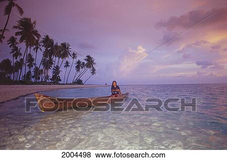 Indonesia, Local Woman In Long Wooden Canoe Along Shoreline, Shallow Ocean, Pink Sky Sunset View Large Photo Image Stock Photo - Indonesia, Local Woman In Long Wooden Canoe Along Shoreline, Shallow Ocean, Pink Sky Sunset. Fotosearch