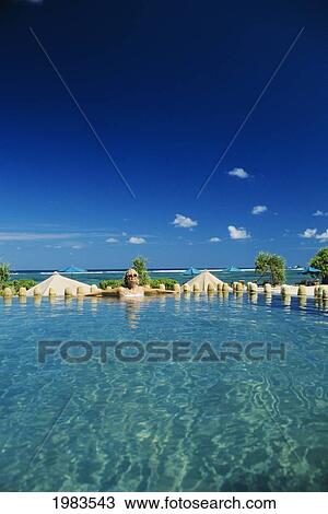 Indonesia, Lombok, Kuta, Novatel Coralia Hotel, Tourist In Swimming Pool. View Large Photo Image Stock Image - Indonesia, Lombok, Kuta, Novatel Coralia Hotel, Tourist In Swimming Pool.. Fotosearch