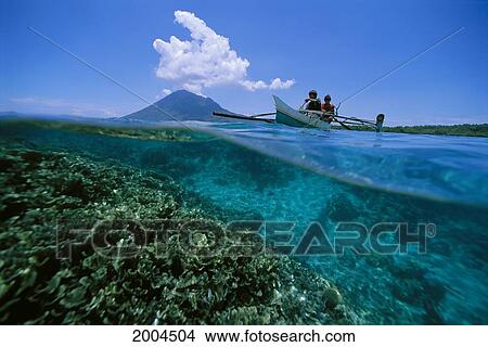 Indonesia, Over/Under View Of Reef Scene And Local Boys In Outrigger Canoe Mountain Background View Large Photo Image Picture - Indonesia, Over/Under View Of Reef Scene And Local Boys In Outrigger Canoe Mountain Background. Fotosearch