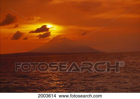 Indonesia, Pura Island, Silhouette Volcano In Distance Across Ocean, Orange Sunset Sky View Large Photo Image Picture - Indonesia, Pura Island, Silhouette Volcano In Distance Across Ocean, Orange Sunset Sky. Fotosearch