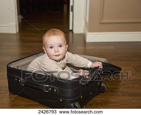 Infant playing in suitcase on hardwood floor; St. Albert, Alberta, Canada View Large Photo Image Stock Image - Infant playing in suitcase on hardwood floor; St. Albert, Alberta, Canada. Fotosearch