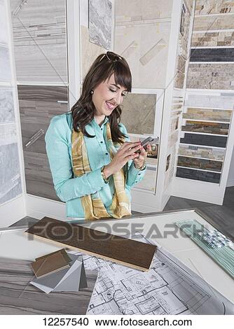 Interior designer selecting tiles in showroom of tile store and texting on phone; Edmonton, Alberta, Canada View Large Photo Image Stock Image - Interior designer selecting tiles in showroom of tile store and texting on phone; Edmonton, Alberta, Canada. Fotosearch
