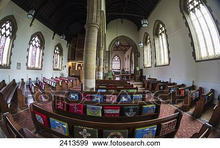 Stock Photo - Interior of a church with colourful times on the backs on wooden pews; Oban, Argyl, Scotland. Fotosearch