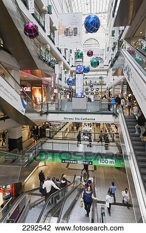 Stock Image - Interior of eaton centre shopping mall and subway escalator; Montreal quebec canada. Fotosearch