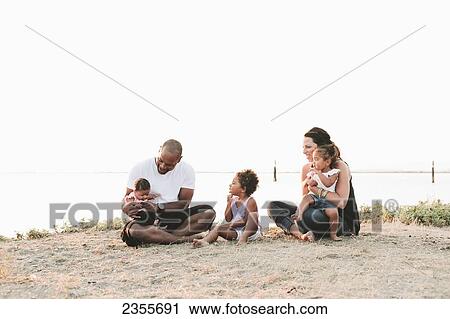 Interracial Family Relaxing On The Beach; British Columbia, Canada View Large Photo Image Stock Image - Interracial Family Relaxing On The Beach; British Columbia, Canada. Fotosearch