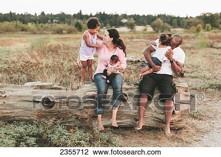 Interracial Family Sitting On Log On Beach; British Columbia, Canada View Large Photo Image Stock Image - Interracial Family Sitting On Log On Beach; British Columbia, Canada. Fotosearch