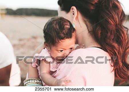 Stock Image - Interracial Mother And Baby Daughter On The Beach; British Columbia, Canada. Fotosearch