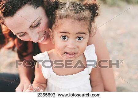 Interracial Mother And Daughter Relaxing On The Beach; British Columbia, Canada View Large Photo Image Stock Image - Interracial Mother And Daughter Relaxing On The Beach; British Columbia, Canada. Fotosearch
