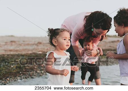 Picture - Interracial Mother And Daughters Wading In Water By The Beach; British Columbia, Canada. Fotosearch