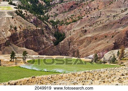 Stock Photo - Irrigation System On Field And Red Rock Near Lillooet, British Columbia. Fotosearch