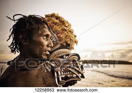Stock Image - Islander with Malagan mask; New Ireland, Papua New Guinea. Fotosearch