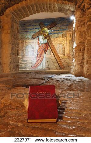 Stock Image - Israel, Close-up of Bible and mural with Jesus Christ; Jerusalem. Fotosearch