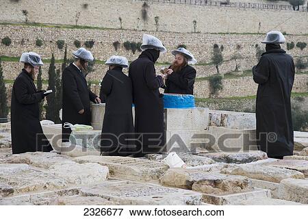 Stock Photo - Israel, Group of orthodox Jews praying at tomb of Or Akhaim at Mount of Olives cemetery; Jerusalem. Fotosearch