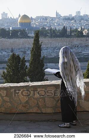 Picture - Israel, Pilgrim praying on Mount of Olives facing Old City; Jerusalem. Fotosearch