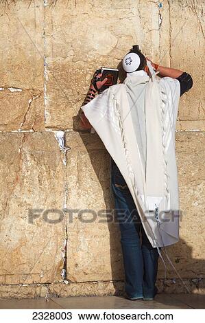 Stock Image - Israel, Rear view of man praying at Wailing wall; Jerusalem. Fotosearch