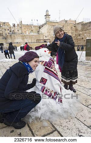 Israel, Western Wall; Jerusalem, 2013, January 10, Girl and woman posing with snowman View Large Photo Image Stock Photograph - Israel, Western Wall; Jerusalem, 2013, January 10, Girl and woman posing with snowman. Fotosearch