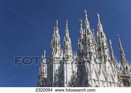 Picture - Italy, Lombardia, Milano, Close up of cathedral spires and blue sky. Fotosearch