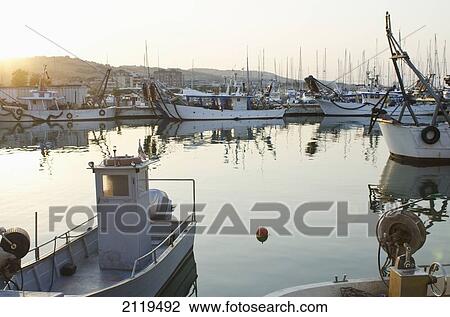 Stock Image - Italy, Marche, Fishing port with anchored fishing boats at sunset; Porto San Giorgio. Fotosearch