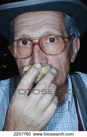 Stock Image - Italy, Piedmont, Truffle Hunter Smelling Truffle At Alba Truffle Festival; Alba. Fotosearch