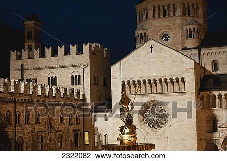 Italy, Trentino, Trento, Cathedral square, Illuminated Neptune fountain at night and stone walls of cathedral and palace in background View Large Photo Image Stock Image - Italy, Trentino, Trento, Cathedral square, Illuminated Neptune fountain at night and stone walls of cathedral and palace in background. Fotosearch