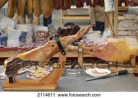 Stock Image - Jamon Serrano Dry-Cured Spanish Ham On A Stand At The Ham And Cheese Festival; Campillos Malaga Spain. Fotosearch
