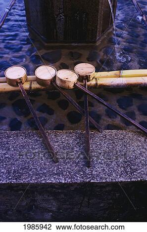 Stock Image - Japan, Bamboo Water Dippers Next To Fountain.. Fotosearch