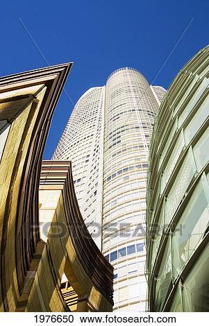 Stock Image - Japan, Roppongi Hills; Tokyo, Upward View Of Mori Tower Framed By Glass And Stone Of Lower Structures. Fotosearch