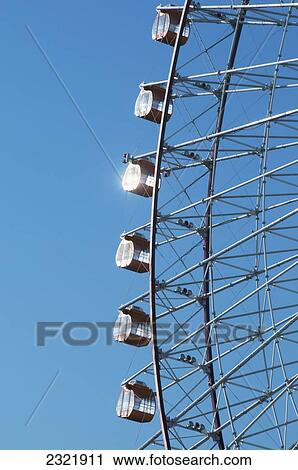 Stock Image - Japan, Tokyo, Ferris wheel against blue sky. Fotosearch