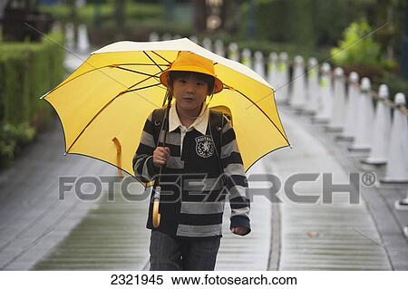 Japan, Tokyo, Girl walking in rain wearing yellow hat and holding yellow umbrella View Large Photo Image Stock Photography - Japan, Tokyo, Girl walking in rain wearing yellow hat and holding yellow umbrella. Fotosearch