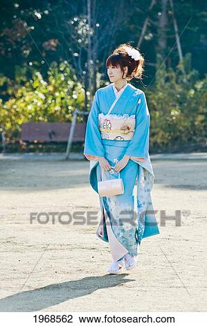Japan, Tokyo, Pretty Japanese Woman In A Blue Kimono Walking Through Garden. View Large Photo Image Stock Image - Japan, Tokyo, Pretty Japanese Woman In A Blue Kimono Walking Through Garden.. Fotosearch
