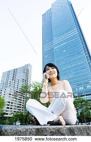Japan, Tokyo, Roppongi, Pretty Young Asian Woman Talks On Cellphone With Modern Office Building In Backround. View Large Photo Image Stock Image - Japan, Tokyo, Roppongi, Pretty Young Asian Woman Talks On Cellphone With Modern Office Building In Backround.. Fotosearch
