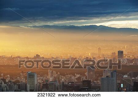 Japan, Tokyo, Sunlight at sunrise over cityscape with mountains in background View Large Photo Image Stock Image - Japan, Tokyo, Sunlight at sunrise over cityscape with mountains in background. Fotosearch