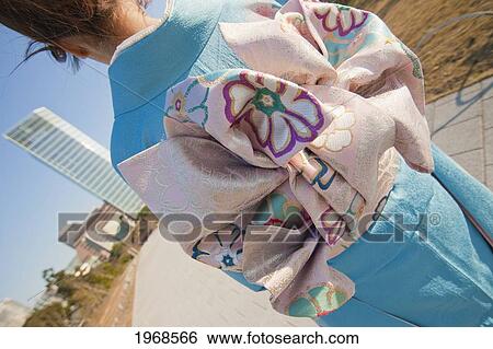 Stock Photograph - Japan, Tokyo, Tilted-Angle Shot Of Obi Sash On Pretty Japanese Girl In Blue Kimono.. Fotosearch