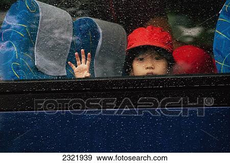 Stock Photo - Japan, Tokyo, Young child looking out bus window. Fotosearch