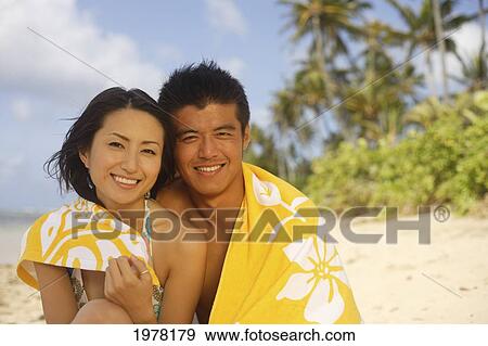 Stock Photo - Japanese Couple On The Beach With Yellow Towel.. Fotosearch