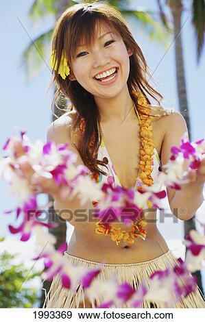 Stock Photo - Japanese Girl In Hula Skirt Holding Out A Lei. Fotosearch