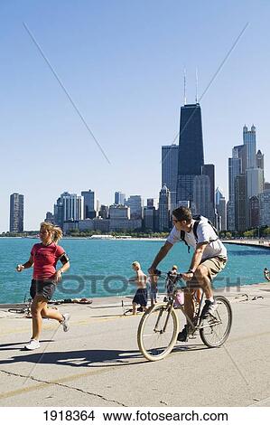 Jogger And Cyclist On Lakefront Path Along Oak Street Beach, Chicago, Illinois, Usa View Large Photo Image Picture - Jogger And Cyclist On Lakefront Path Along Oak Street Beach, Chicago, Illinois, Usa. Fotosearch