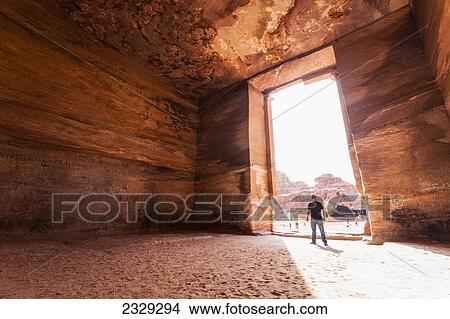 Jordan, it measures 50 metres wide by approximately 45 metres high; Petra, Man contemplating Ad Deir (Arabic for The Monastery) is a monumental building carved out of rock in ancient city of Petra. Built by Nabataeans in 1st century View Large Photo Image Picture - Jordan, it measures 50 metres wide by approximately 45 metres high; Petra, Man contemplating Ad Deir (Arabic for The Monastery) is a monumental building carved out of rock in ancient city of Petra. Built by Nabataeans in 1st century. Fotosearch