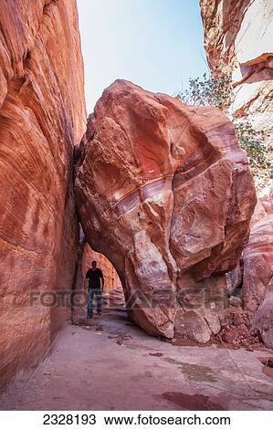 Jordan, Tourist walking under boulder; Petra View Large Photo Image Stock Image - Jordan, Tourist walking under boulder; Petra. Fotosearch