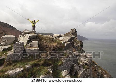 Jubilant Female Walker On Top Of Rocks Along The South West Coast Path Near Lynmouth, Exmoor, United Kingdom View Large Photo Image Stock Image - Jubilant Female Walker On Top Of Rocks Along The South West Coast Path Near Lynmouth, Exmoor, United Kingdom. Fotosearch