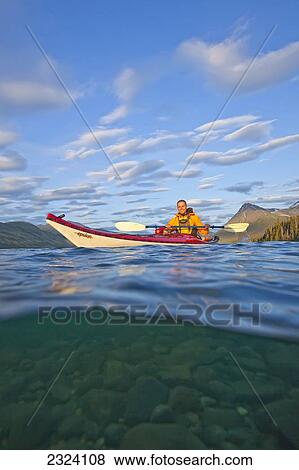 Kayaker on Kusawa Lake at sunset, shot half above and half below water; Yukon, Canada View Large Photo Image Stock Photo - Kayaker on Kusawa Lake at sunset, shot half above and half below water; Yukon, Canada. Fotosearch