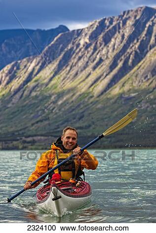 Kayaker on Kusawa Lake with the setting sun hitting the mountains; Yukon, Canada View Large Photo Image Stock Image - Kayaker on Kusawa Lake with the setting sun hitting the mountains; Yukon, Canada. Fotosearch